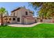 Charming two-story home with a well-maintained lawn, brick pathway, and mature trees offering shade at 635 N Yale Dr, Gilbert, AZ 85234
