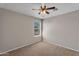 Carpeted bedroom features a window, ceiling fan, and neutral-color walls creating a clean space at 6469 W Ruth Ave, Glendale, AZ 85302