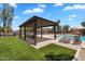 Shaded pergola with seating near the community pool and manicured green space for outdoor relaxation at 6469 W Ruth Ave, Glendale, AZ 85302