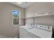 Bright laundry room with modern washer and dryer, plus convenient built-in shelving at 6469 W Ruth Ave, Glendale, AZ 85302