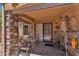 Covered patio with stone accents, outdoor dining set, and decorative wall art at 6469 W Ruth Ave, Glendale, AZ 85302
