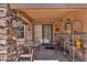 Covered patio with stone accents, outdoor dining set, and decorative wall art at 6469 W Ruth Ave, Glendale, AZ 85302