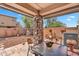 Covered patio featuring stone column, pavers, backyard view, and outdoor dining set at 6469 W Ruth Ave, Glendale, AZ 85302