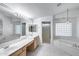 Bright bathroom with double sink vanity, soaking tub, and glass-enclosed shower at 7217 S Hazelton Ln, Tempe, AZ 85283