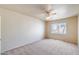 This is a simple bedroom with a ceiling fan, neutral walls, and a window at 7217 S Hazelton Ln, Tempe, AZ 85283