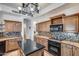 Modern kitchen featuring granite countertops, wooden cabinetry, mosaic backsplash, and high-end appliances at 7217 S Hazelton Ln, Tempe, AZ 85283