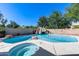 Sparkling pool and hot tub with rock waterfall feature and surrounding greenery creating a private outdoor space at 7217 S Hazelton Ln, Tempe, AZ 85283
