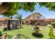 Beautiful backyard with turf, patio, outdoor seating, fountain and grill area at 7512 W Tonto Dr, Glendale, AZ 85308