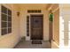 Inviting entryway featuring a rustic wood door and a charming welcome mat at 7512 W Tonto Dr, Glendale, AZ 85308