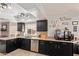 Traditional kitchen features black cabinets, tan granite counters, and stainless steel appliances at 7512 W Tonto Dr, Glendale, AZ 85308