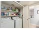 Laundry room features a washer, dryer, storage shelves, and tile flooring at 7512 W Tonto Dr, Glendale, AZ 85308