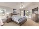 Bright main bedroom featuring a ceiling fan, balcony, and an ensuite bathroom at 7512 W Tonto Dr, Glendale, AZ 85308