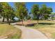 Curving sidewalk leads through the lush green golf course, perfect for a walk at 7512 W Tonto Dr, Glendale, AZ 85308