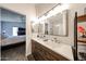 Bright bathroom features a dual sink vanity with a wood base and a peek into the bedroom at 8521 W Mauna Loa Ln, Peoria, AZ 85381