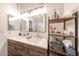 Bathroom showcasing double sinks, wood storage cabinet, and shower behind the mirror at 8521 W Mauna Loa Ln, Peoria, AZ 85381