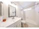 Cozy bathroom features a white vanity, tub and shower combo, and window at 8521 W Mauna Loa Ln, Peoria, AZ 85381