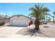 Charming one story house with a two car garage, desert landscaping, and a palm tree at 8521 W Mauna Loa Ln, Peoria, AZ 85381