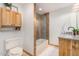 Bathroom featuring a tub-shower combo with wood cabinets, white walls, and tile surround at 8767 W Villa Hermosa --, Peoria, AZ 85383