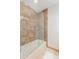 Well-lit bathroom featuring a shower over tub with glass doors and neutral tile surround at 8767 W Villa Hermosa --, Peoria, AZ 85383
