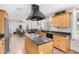 Bright kitchen boasts an island cooktop, black appliances, and light wood cabinets at 8767 W Villa Hermosa --, Peoria, AZ 85383