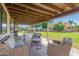 Relaxing covered patio with ample seating, a grill, and views of the well-maintained lawn at 8767 W Villa Hermosa --, Peoria, AZ 85383