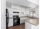 Bright kitchen with white cabinets, stone countertops, a black range oven, and stainless steel sink at 9118 W Cameron Dr, Peoria, AZ 85345