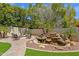 Beautiful backyard with a rock waterfall feature, fire pit, and lush greenery at 9241 S 50Th St, Phoenix, AZ 85044