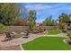 Beautiful backyard with lush greenery, a fire pit, and a charming rock waterfall feature at 9241 S 50Th St, Phoenix, AZ 85044