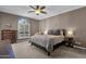 Comfortable bedroom featuring a ceiling fan, cozy bed, stylish lamps, and a window with natural light at 9241 S 50Th St, Phoenix, AZ 85044