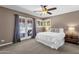 Serene bedroom with a ceiling fan, French doors, and a window providing natural light and fresh air at 9241 S 50Th St, Phoenix, AZ 85044
