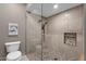 Modern tiled shower with glass enclosure, pebble floor, and built-in shelving niche at 9241 S 50Th St, Phoenix, AZ 85044