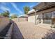 Backyard with a gravel ground, block wall fence, patio and a view of the blue sky at 9463 E Jenan Dr, Scottsdale, AZ 85260