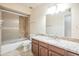 The bathroom features wood cabinets, granite countertops, and a tub-shower combo, stylishly appointed at 9463 E Jenan Dr, Scottsdale, AZ 85260