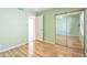 The space is inviting with light green walls, wood floors, mirrored closet and adjacent entry at 9463 E Jenan Dr, Scottsdale, AZ 85260