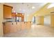 Open-concept kitchen featuring pendant lighting, stainless steel appliances, and a breakfast bar that opens to the living area at 9463 E Jenan Dr, Scottsdale, AZ 85260