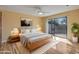 Well-lit main bedroom with a sliding door to the outside patio and a modern ceiling fan above at 9463 E Jenan Dr, Scottsdale, AZ 85260