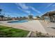 Inviting community pool with a deck, shaded seating, and well-maintained landscaping at 9463 E Jenan Dr, Scottsdale, AZ 85260