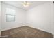 Clean bedroom featuring a ceiling fan, bright natural light, and soft carpet floors at 9837 E Tiburon Ave, Mesa, AZ 85212
