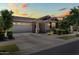 A cozy single-Gathering home showcases classic exterior features, a two-car garage and beautiful curb appeal at 9837 E Tiburon Ave, Mesa, AZ 85212