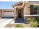 Inviting front entrance with a charming porch, stone accents, well-manicured landscaping, and a two-car garage at 9837 E Tiburon Ave, Mesa, AZ 85212