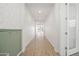 Bright hallway with stylish wood-look tile flooring, decorative wainscoting, and neutral paint throughout the home at 9837 E Tiburon Ave, Mesa, AZ 85212