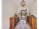 Elegant foyer with stone floors, wooden cabinets, and an open doorway to the exterior at 10182 E Gilded Perch Dr, Scottsdale, AZ 85255