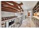 Open hallway with wood beam ceilings, iron railing, and custom built-in storage and bookshelves at 10182 E Gilded Perch Dr, Scottsdale, AZ 85255