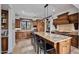 Spacious kitchen featuring a large island with seating, wood cabinets, and stone flooring at 10182 E Gilded Perch Dr, Scottsdale, AZ 85255