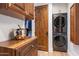 Convenient laundry area with stacked washer/dryer, custom wood cabinetry, and easy access from the walk-in closet at 10182 E Gilded Perch Dr, Scottsdale, AZ 85255