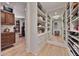 Spacious walk-in closet boasting custom shelving, hardwood floors, and a full-length mirror for a complete wardrobe experience at 10182 E Gilded Perch Dr, Scottsdale, AZ 85255