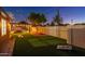 Expansive backyard with lush turf, a covered patio with grill area, and a charming rock waterfall feature near the pool at 10240 N 34Th Pl, Phoenix, AZ 85028
