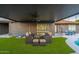 Inviting outdoor patio with a ceiling fan, outdoor seating, cornhole, lush turf, and a view of the sparkling pool at 10240 N 34Th Pl, Phoenix, AZ 85028