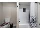 Bright bathroom featuring a bathtub and shower with a patterned shower curtain and unique toilet seat design at 10240 N 34Th Pl, Phoenix, AZ 85028