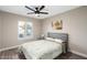 Bright bedroom with an overhead ceiling fan, wood-look floors, and large window with views of the lush outdoor landscape at 10240 N 34Th Pl, Phoenix, AZ 85028